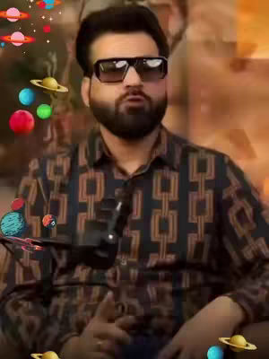 The cover image features a man with short, dark hair and a beard wearing sunglasses and a patterned shirt. A microphone is visible, suggesting a podcast or video recording setup. Animated planets and stars are added as visual elements.