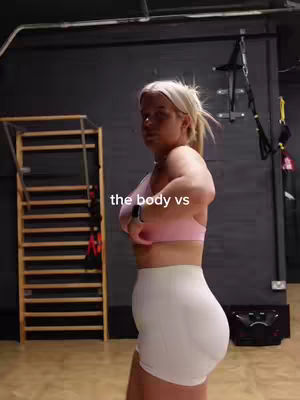 A woman in gym attire stands in a gym, with the phrase 'the body vs' overlaid on the image.
