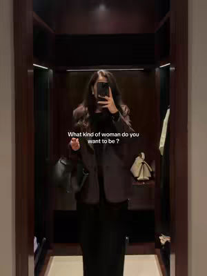 A woman is taking a selfie in a walk- in closet with a mirrored door. The hook text is white and placed in the center of the image.