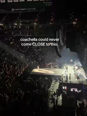 An elevated view of a large concert venue with a stage and a massive audience. A spotlight shines on a figure in the center of the stage. The text overlay reads "coachella could never come CLOSE to this."