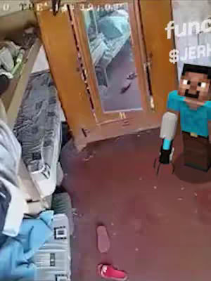 The image features an interior shot, seemingly captured from a camera positioned in a corner. The view includes a partially open wooden door with a mirror reflecting a room with a person lying in bed. In the foreground on the right side stands a blocky, pixelated figure, resembling a character from Minecraft, with a tool raised in one hand.. The floor is a reddish-brown color, and the bottom is partially taken up by a pair of shoes. A cluttered area including furniture and possessions is visible on the left, adding a sense of disorder, suggesting possible comedic intent. The overlay text sits along the right side of the image.