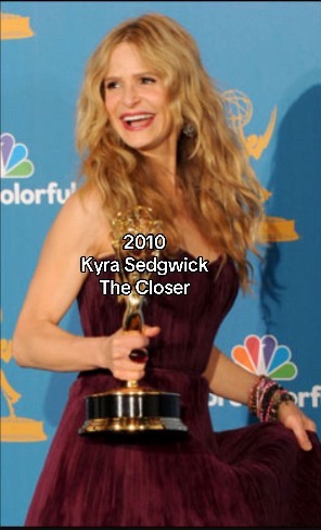 A woman with blonde hair is holding an Emmy award. She is smiling at the camera wearing a burgundy dress. Text overlayed on the image says "2010", "Kyra Sedgwick", and "The Closer". The background is a colorful stage setting, with the NBC logo on the left.