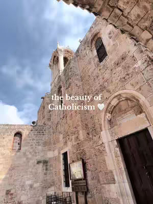 An upward angled shot of an older stone building with arched windows and a bell tower peeking out the top. The sky is cloudy with hints of blue. Text is overlaid on the image.