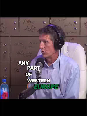 A man with headphones is speaking into a microphone. Text is overlayed on the image.