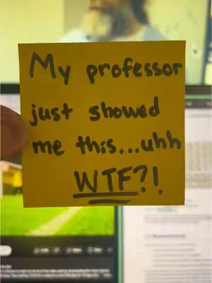 A yellow sticky note with black handwritten text is held in front of a computer monitor, which displays a person in the background. The sticky note is the focal point, and its message is emphasized by the composition.
