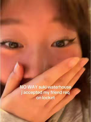 A close-up shot focuses on a person's eyes and a hand covering their mouth. The person's eyes are wide and expressive, framed by dark eyeliner. The hand, with visible nails, covers the lower part of the face, suggesting surprise or excitement. Overlay text is present at the bottom.