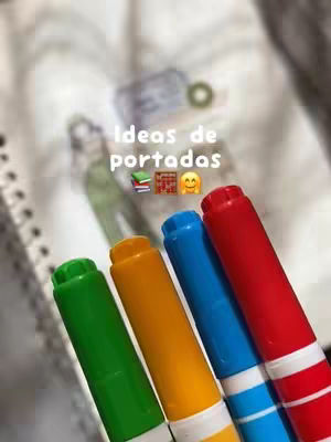 The cover image displays a collection of colorful markers in the foreground. The markers are green, yellow, blue, and red. Behind the markers it is a notepad and the hook text reads 'Ideas de portadas' with emojis.