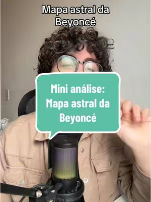 A man with curly hair and glasses is centered in the frame, with a microphone in front of him. He's wearing a tan jacket over a lighter shirt, and the background is a neutral color. A speech bubble-shaped graphic is in front of the man with the title of the video written on it.