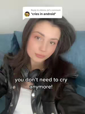 A young woman with long dark hair is centered in the frame, smiling slightly. She wears a black leather jacket over a white top. A speech bubble overlay appears in the top-left corner containing text. Below her chin, the text "you don't need to cry anymore!" is displayed in white.