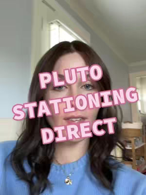 A woman with long dark hair and blue eyes is in the center of the frame. She is wearing a light blue sweater and a necklace with a small pendant. The background is a blurry room with a window and a wall. Text overlays are placed on the screen, featuring the words "PLUTO STATIONING DIRECT."
