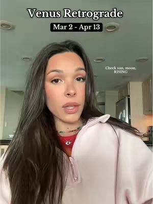 A woman with long brown hair faces the camera, with text overlays at the top and to the right. The background is a kitchen with overhead lights.