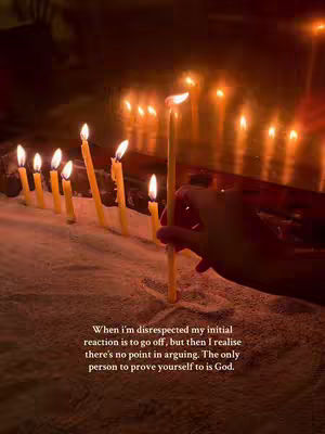 The image shows a close-up of lit candles, arranged in a row on a surface that resembles sand. The background is dark, suggesting a dim environment, and there are also additional lit candles behind the main row of candles. A hand is holding one candle upright, slightly apart from the others. The lighting is warm and seems to emanate from the flames, creating a sense of reverence or contemplation. Text overlayed on the image provides a message of faith and dealing with disrespect.
