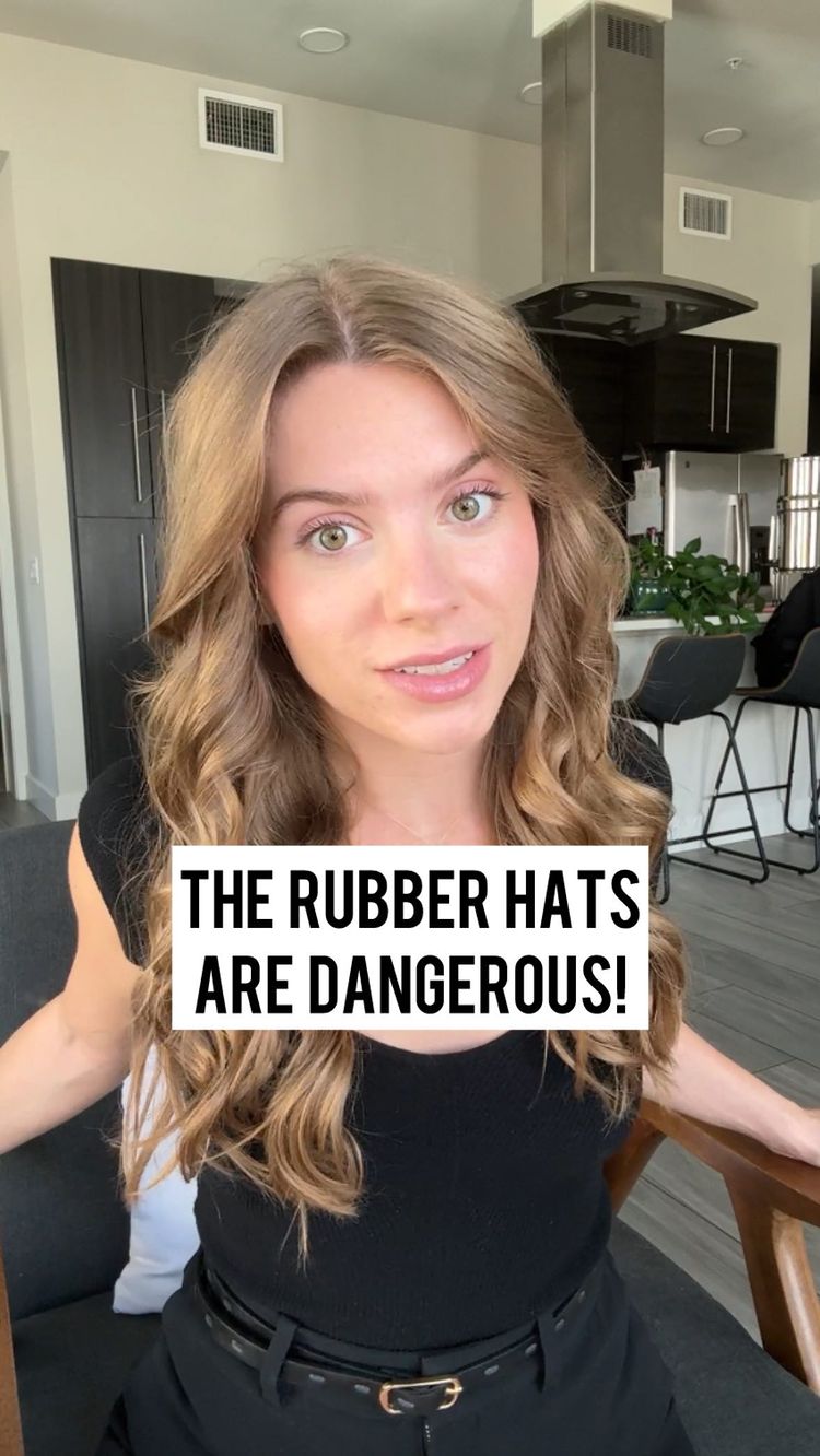 A woman with long wavy blonde hair is seated indoors, looking towards the camera with a conversational expression. She is wearing a black top and the background features what looks like a modern kitchen and living area. A white box with text overlay covers the lower center of the image.