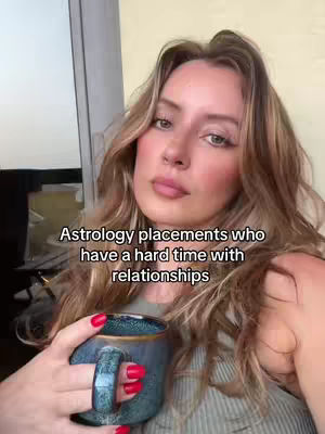 A woman is holding a blue mug and looking into the camera. She has long, wavy blonde hair and red nail polish. Text overlay appears on the image.