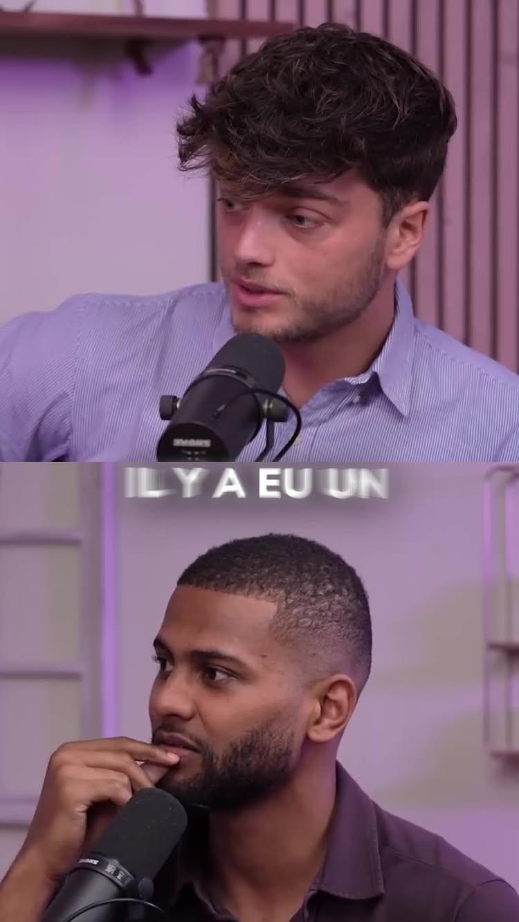 The cover image is a split screen featuring two men. The top half shows a man with light skin, short brown hair styled with a side part, and a blue striped shirt. He's holding a microphone. The bottom half features a man with a shaved haircut, dark skin, and is also holding a microphone. Both appear to be in a studio setting with soft lighting and a purple background.