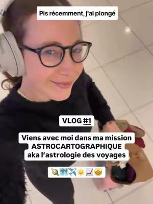 A woman wearing glasses, headphones, and a black top, smiling and walking while holding a bag. Text overlays indicate this is a vlog about astrocartography.