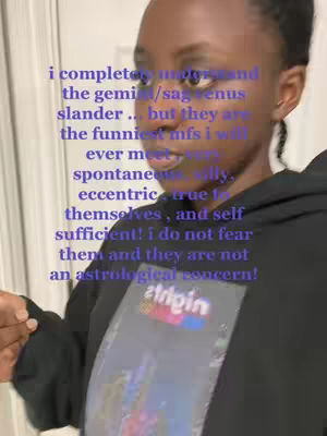 A person of color is captured in a close-up, angled shot. The individual is wearing a black hoodie and appears to be in an indoor setting. Overlaid on the image is text in a purple hue, with details partially obscured by the person's clothing. The composition focuses on the person's upper body, with the text positioned on the left.