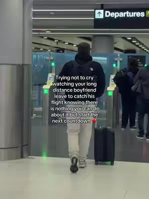 A person walking away from the camera in an airport, presumably after seeing their boyfriend leave. Adding context the theme of long distance relationships.