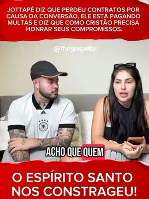The cover image shows a man and a woman seated. The man, on the left, wears a black cap, white t-shirt with black stripes on the shoulders, tattoos on his arms and a serious expression. The woman has long dark hair and is wearing a black top. The background is a mix of white and red banners with some text, including a bottom banner saying, "O ESPÍRITO SANTO NOS CONSTRAGEU!".