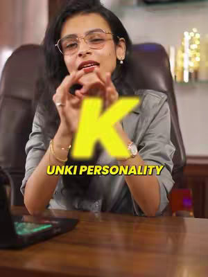 The cover image features a woman in glasses and a gray blazer, seated in a chair, with a large yellow "K" superimposed over her upper body. The text "UNKI PERSONALITY" is displayed below the yellow "K". A desk and laptop are visible in the foreground, and the setting suggests an office or home study.
