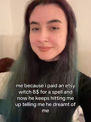 A selfie-style shot featuring a young woman with long, multi-colored hair. She is positioned in the mid-ground with a neutral expression, looking slightly off-camera. Text overlayed on the image shares a humorous anecdote about a spell.