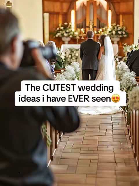 A wedding ceremony is in progress. A photographer in the foreground is capturing the moment. The bride and groom stand at the altar as the ceremony happens. Soft lighting emphasizes the joyful ambiance with a floor covered in decorative patterns.