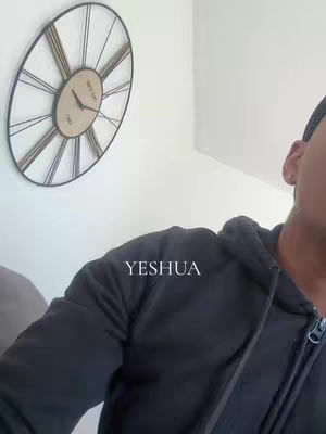 The cover image features a man in a black hoodie in the lower right, his face partially visible. The word 'YESHUA' is overlaid in white text. A large clock hangs on the wall behind him.
