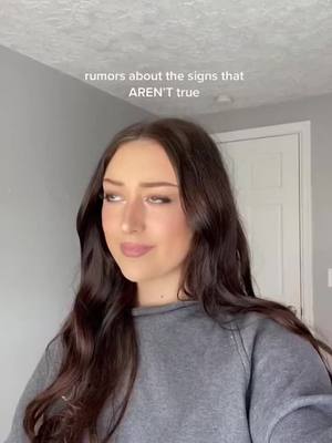A young woman with long, dark hair is looking slightly to the side with a contemplative expression. Text overlay at the top reads, "rumors about the signs that AREN'T true."