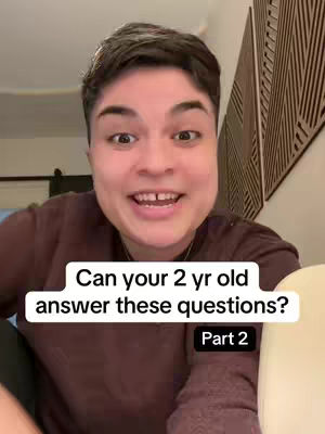 A person with short dark hair smiles directly at the camera. Above them, text overlaid in a white box reads, "Can your 2 yr old answer these questions?" The text "Part 2" is below the text in a black box.