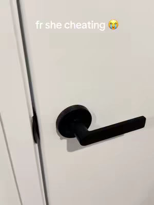 An eye-level shot focuses on a white door and its black handle, angled from the viewer's perspective. Above the handle, text overlays. The door is clean and simple, with a smooth surface.