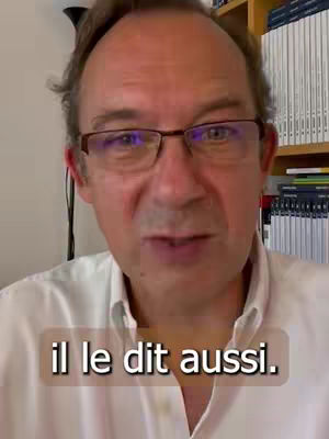 A man wearing glasses and a white shirt is speaking directly to the camera with the text overlayed at the bottom. The background includes a soft-focus home office with a partially visible bookshelf.