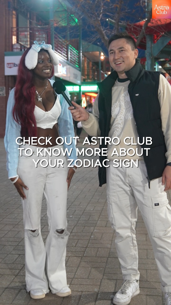 A cover image of a man interviewing a woman on a city street. The woman is holding a microphone. Overlaid on the image is text that reads "CHECK OUT ASTRO CLUB TO KNOW MORE ABOUT YOUR ZODIAC SIGN".