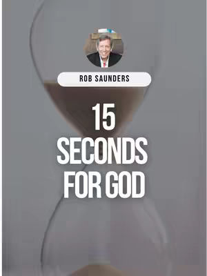 The image is a vertical composition featuring an hourglass with sand flowing from top to bottom, set against a blurred gray background. Above the hourglass is a small circular image of a man, identified by the text "ROB SAUNDERS" in a white banner below the image. The main text overlay, "15 SECONDS FOR GOD", is in a bold, white font. The overall aesthetic is simple and focuses on the message.