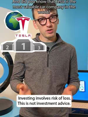 A man wearing glasses and a gray zip-up sweater speaks in front of a blurry blue background. A podium graphic with a Tesla logo and a stylized globe with the Tesla logo are behind him. Below, text warns of investment risks.