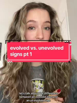 A woman with long wavy hair looks towards the camera. A red rectangle with white text reading "evolved vs. unevolved signs pt 1" is overlaid on her face. The background is a blurred interior. Below this a line of text is present, in a smaller font.