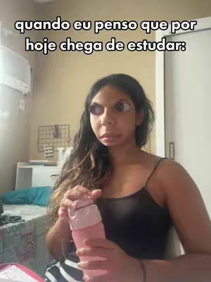 A woman with long dark hair and large cartoonish eyes looks at the camera, holding a pink bottle. Text in white is at the top of the image.