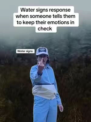 The cover image shows a person in a bright blue jumpsuit, standing outdoors. The person is making a rude hand gesture, with a middle finger raised at the viewer. Above, white text on a black background says, "Water signs response when someone tells them to keep their emotions in check." In a smaller white rectangular box, above the head of the person, at the top centered, states "Water signs:" The background is blurred and dark with some green.