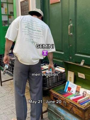The image shows a man from the back, wearing a white t-shirt with text on it and a baseball cap, standing in front of a green door with a sign above it. He seems to be browsing through a box of books, which is part of a book stand setup on the sidewalk. The overall composition is a mix of urban and literary elements, with the color palette centered around green, white, and the various colors of the books.