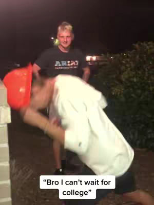 Two young men are in frame at night. One leans into the camera with an orange construction hat, while the other stands behind him. An attached text overlay reads, "Bro I can't wait for college."