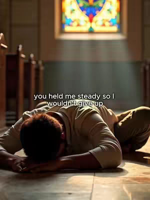 A man lies face down on a wooden floor in a church setting, with a blurred background. Overhead, a stained-glass window provides a colorful backdrop, while the main subject is lit by soft, natural light.