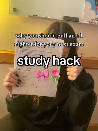 A person is holding up a paper in front of their face, the text that is displayed says why you should pull an all nighter for your next exam, study hack, with a pink bow and pink flower graphic.