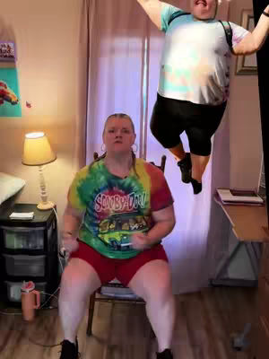 The cover image shows a woman performing a seated cardio workout. A superimposed image of a man in the air with a t-shirt and a black short. The woman is in a chair, wearing red shorts and a colorful t-shirt.