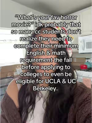 A selfie-style shot features a woman with long, dark hair in a casual indoor setting. She's wearing a brown cardigan over a white top or undershirt. Text overlays, in a sans-serif font, are present near the top of the frame.