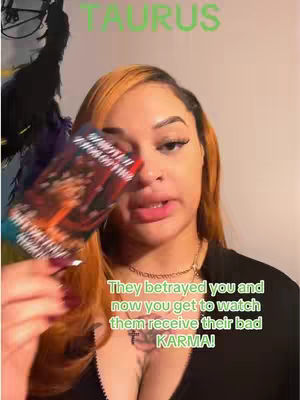 A woman with orange hair is holding a deck of tarot cards in front of her face. Text overlays are present, including the name "TAURUS" in green and a quote about karma at the bottom. The lighting seems to be natural, with a focus on the woman.