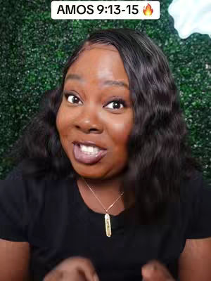 A woman with dark skin and long black hair is looking at the camera with a slight smile. She has a gold necklace and is wearing a black shirt. In the background, there's a textured green backdrop.