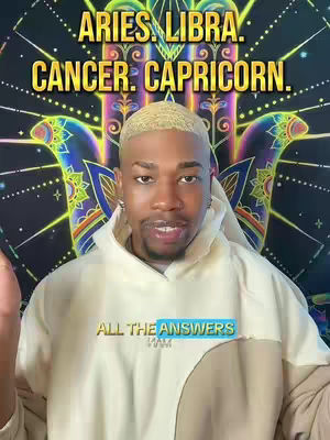A man with blonde hair is in the center of the frame, looking directly at the camera. He wears a cream-colored hoodie. Behind him is a tapestry or wall hanging with a hand symbol, radiating colorful patterns and light. The text "ARIES. LIBRA. CANCER. CAPRICORN." is written at the top of the image in a gold color. Below the creator, the text reads "ALL THE ANSWERS IAM" inside a blue rectangle.