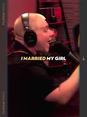 A man with a bald head wearing a headset is shown in profile, mid-sentence, with the text 'I MARRIED MY GIRL' overlaid. The background is a blurry indoor setting.
