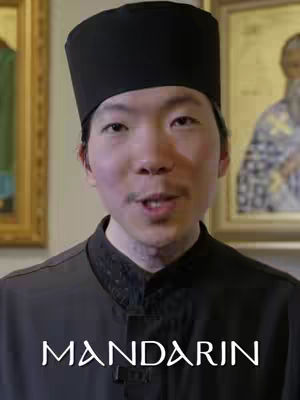 The cover image shows a close-up of a man wearing a black hat and a dark collared shirt, speaking or gesturing. The background features framed paintings or icons, suggesting a religious or historical setting. Overlayed at the bottom is the text 'MANDARIN'.