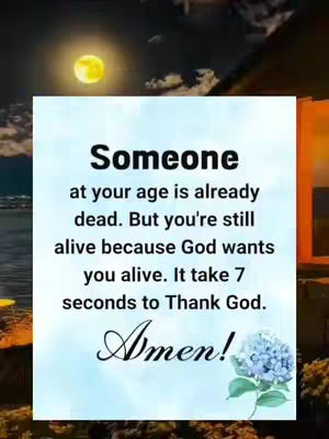 The image features a quote presented within a soft, light blue frame against a layered background. The top layer appears to be a night sky scene with a crescent moon, and a blurred background suggests mountains or a natural setting. The central focus is a white rectangular frame containing the text 'Someone at your age is already dead. But you're still alive because God wants you alive. It take 7 seconds to Thank God. Amen!' A small illustration of a blue flower with a green stem and leaves is positioned at the bottom right of the frame.