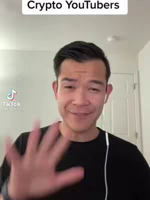 A man in a black shirt is filming himself in what appears to be a room, with a white wall and a white door behind him. He is smiling and waving his hand towards the camera, and there is text at the top of the image.